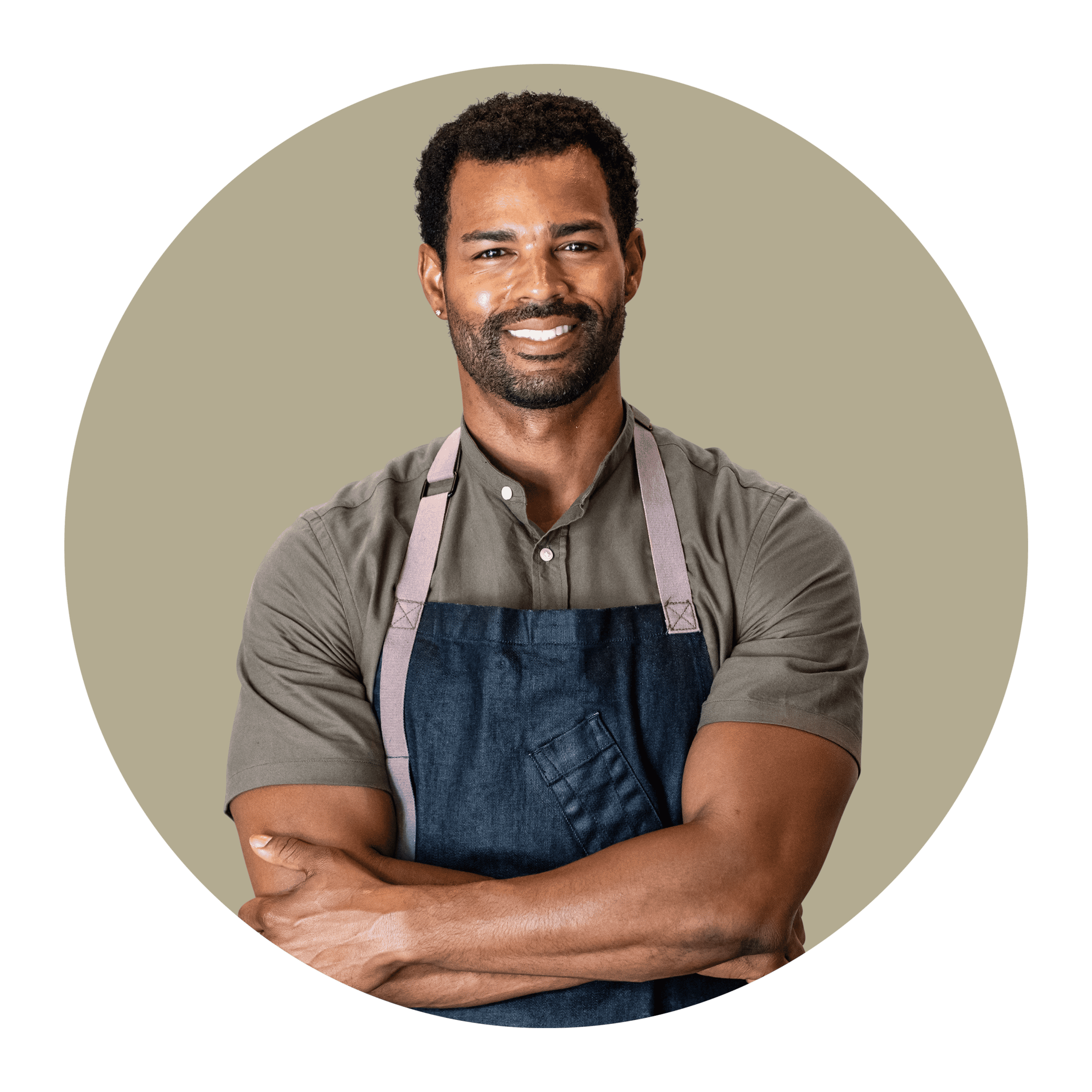 Gezicht van man met korte krullende haar en baard, lachend met grijs achtergrond.