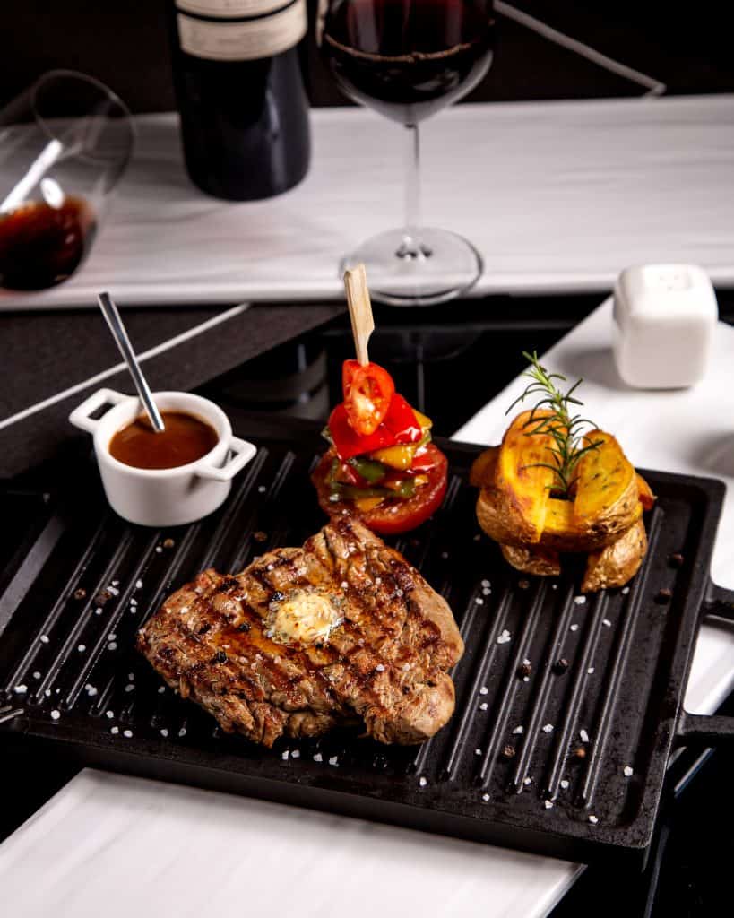 Romige steak met groenten en wijn, perfect bereid op grill voor de ultieme smaakervaring.