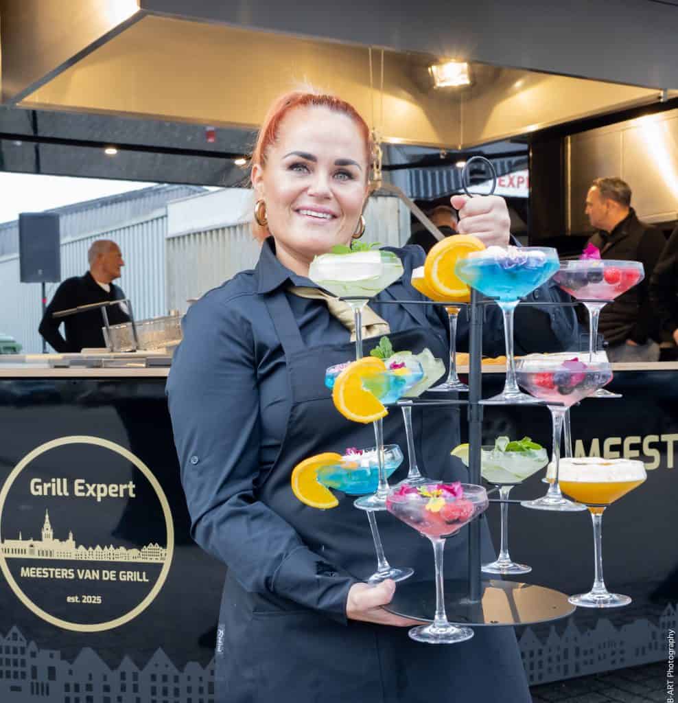 Vrolijke vrouw serveert kleurrijke cocktails bij Grill Expert in Nederland.